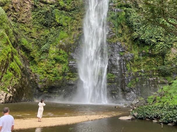 A traveler admiring a Volta Region waterfall